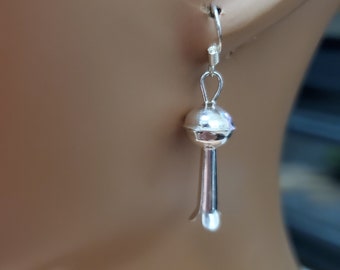 Puede incluir: Pendientes de plata con forma de gota, con una bola redonda en la parte superior.