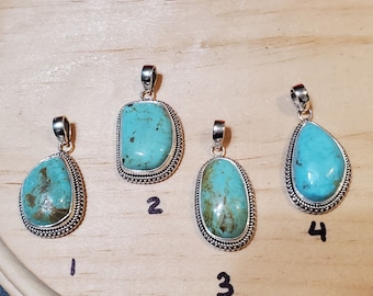 May include: Four turquoise stone pendants with silver settings. The stones are different shapes and sizes. The pendants are numbered 1 through 4.