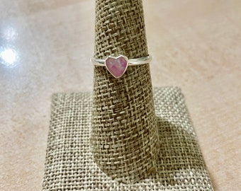 May include: A silver ring with a pink heart-shaped stone.