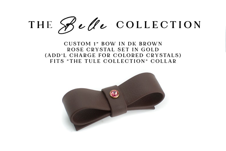 May include: Dark brown leather bow, approximately 1 inch, with a small rose-colored crystal in a gold setting.  The text on the image reads: 'THE Belle COLLECTION', 'CUSTOM 1' BOW IN DK BROWN ROSE CRYSTAL SET IN GOLD (ADD'L CHARGE FOR COLORED CRYSTALS) FITS 'THE TULE COLLECTION' COLLAR.  The bow is a decorative accessory, suitable for collars or other apparel.