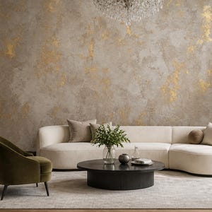 May include: A living room featuring a textured beige wall with gold leaf accents, a curved cream-colored sofa, a round black coffee table, an olive green armchair, a crystal chandelier, and a black fireplace with an arched mirror above it.