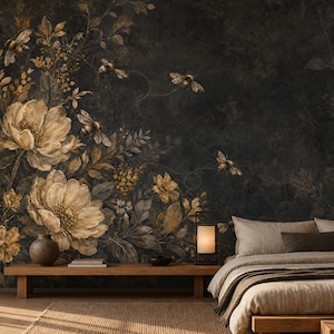 May include: A dark charcoal wall mural featuring large, muted gold and cream-coloured floral arrangements with detailed leaves and small flying bees. The mural serves as a backdrop for a bedroom with a low wooden bed frame and a wooden bench.