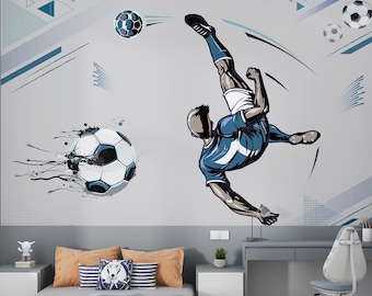 May include: A gray wall mural with a blue and white illustration of a soccer player kicking a ball. The player is wearing a blue jersey with a white number 7 on it. The mural is in a bedroom with a gray desk, a white chair, and a bed with gray and white bedding.