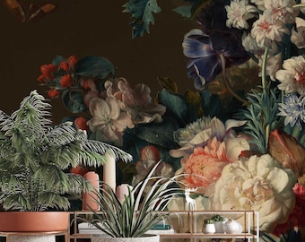 Può includere: Due piante in vaso con un vaso a motivi marroni e bianchi e un vaso in terracotta su supporti in metallo dorato davanti a un muro marrone scuro con un grande murale floreale con fiori rosa, bianchi e blu.