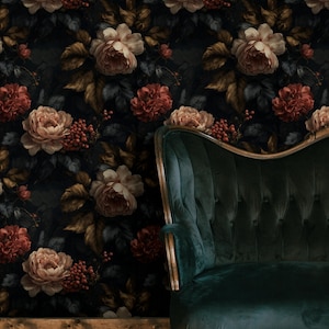 May include: A dark floral wallpaper with large, vintage-style roses in cream, peach, and burgundy. A dark teal velvet sofa with gold trim is positioned in front of the wallpaper, creating a moody, elegant interior design.