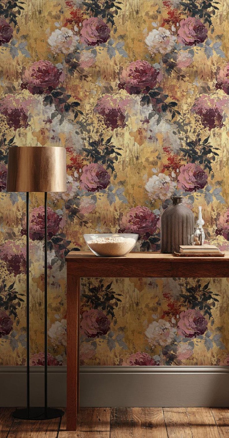 May include: Floral wallpaper featuring a gold backdrop and large, painterly roses in pink, burgundy, and white. A wooden table displays a bowl, vase, and decorative items. A floor lamp with a gold shade stands to the left.