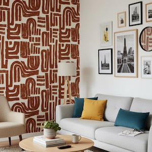 Puede incluir: Salón moderno con sofá gris, mesa de centro redonda de madera y pared decorativa estampada. Cojines decorativos en verde azulado y amarillo añaden color. Obras de arte enmarcadas y una lámpara de pie completan el espacio.