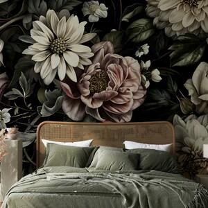 Puede incluir: Una cabecera de cama verde oscuro con un dise&ntilde;o de rat&aacute;n tejido, un edred&oacute;n verde y dos almohadas verdes. La cabecera est&aacute; delante de un papel tapiz floral oscuro con grandes flores blancas, rosas y crema.