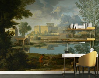 Op de afbeelding: Een vintage-stijl schilderij van een landschap met een meer, een kasteel en bergen op de achtergrond. Het schilderij is gedrukt op een muurschildering en wordt getoond in een thuiskantoor met een bureau, stoel en boekenkast.