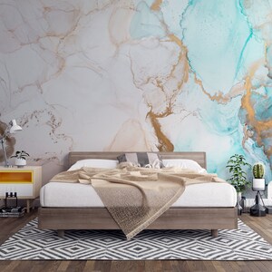 May include: A bedroom with a bed, a nightstand, and a rug. The wall is painted with a blue and gold abstract design.