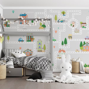 May include: A child's bedroom with a gray loft bed and a white rabbit stuffed animal. The wall behind the bed has a gray and white wallpaper with a road and city theme. The wallpaper features houses, cars, trees, and a scooter. The bed has a black and white chevron patterned comforter and a gray and white striped pillow.