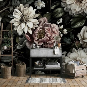 Puede incluir: Un papel tapiz floral oscuro con grandes flores blancas, rosas y crema. El papel tapiz est&aacute; en un ba&ntilde;o con un lavabo, toallas y una caja de madera.