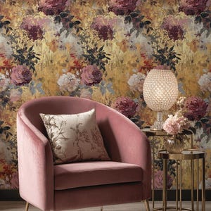 May include: A blush pink velvet armchair with gold legs and a patterned cushion. The chair is set against a floral wallpaper. A crystal lamp and gold side tables complete the elegant interior design, creating a luxurious atmosphere.