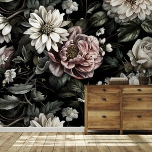 Puede incluir: Un papel tapiz floral oscuro con grandes flores rosas, blancas y crema sobre un fondo negro. El papel tapiz se muestra en una habitaci&oacute;n con una c&oacute;moda de madera y una l&aacute;mpara.