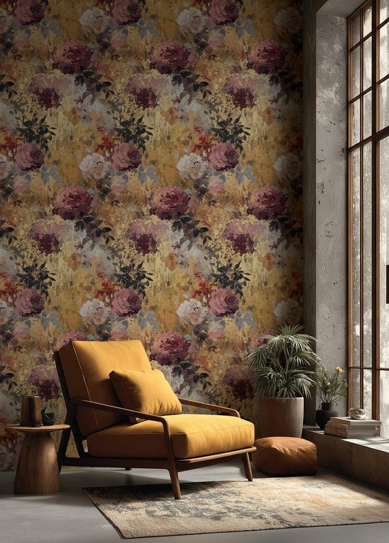 May include: A room with floral wallpaper featuring large, watercolour-style roses in pink, burgundy, and cream against a golden-yellow backdrop. A mustard-coloured armchair and side table are in the foreground.