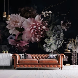 May include: A dark brown leather sofa with buttoned upholstery sits in front of a wall with a large floral mural. The mural features pink, purple, and white flowers on a black background.