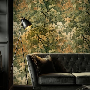 May include: A living room scene featuring a dark gray tufted sofa with a matching throw pillow. A black floor lamp with a gold interior shade illuminates the scene. The wallpaper has a green and gold leaf pattern.