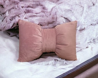 Pink velvet throw pillow in a unique bow design for the bedroom