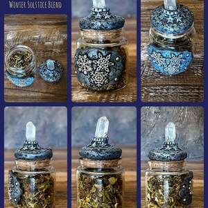 May include: A small glass jar with a cork lid and a crystal top. The jar is filled with dried herbs and has a blue and silver snowflake design on the side. The jar is labeled "Her Enchanted Creations Winter Solstice Blend".