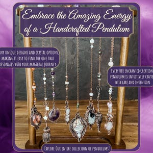 May include: A wooden stand with a variety of handcrafted pendulums with different crystal and gemstone options. The pendulums are made with copper wire and feature various crystals, including amethyst, agate, and clear quartz. The stand is decorated with a purple and white background.