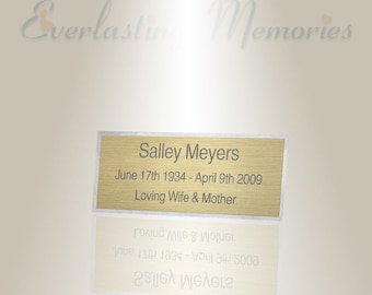 Puede incluir: Una placa dorada con borde plateado, en memoria de Salley Meyers. La placa dice "Salley Meyers, June 17th 1934 - April 9th 2009, Loving Wife & Mother".