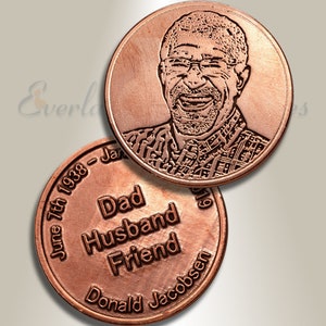 May include: Two copper memorial coins. One side features a portrait of a man with a smile. The other side has the text "June 7th 1938 - Jan" and "Dad Husband Friend Donald Jacobsen".