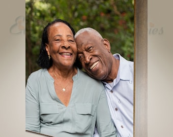 May include: A wooden block featuring a photograph of an elderly couple smiling. The woman wears a light green shirt and a gold necklace. The man wears a light blue shirt. The wooden frame has a natural wood grain finish.