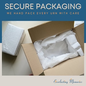 May include: A brown cardboard box with a white tissue paper lining. The box is open and the tissue paper is visible. The text "Secure Packaging" and "We hand pack every urn with care" is visible at the top of the image. The text "Everlasting Memories" is visible at the bottom of the image.