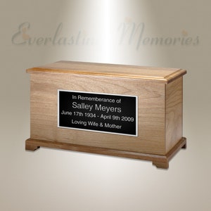 Pode incluir: Uma urna de cremação de madeira com uma placa preta que diz "In Remembrance of Salley Meyers June 17th 1934 - April 9th 2009 Loving Wife & Mother"