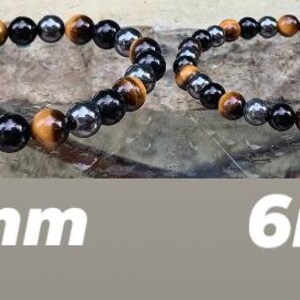 May include: Two beaded bracelets featuring alternating round tiger eye, black obsidian, and metallic hematite beads. The left bracelet is labeled 8mm and the right bracelet is labeled 6mm, indicating the specific diameter of the beads used in each piece.