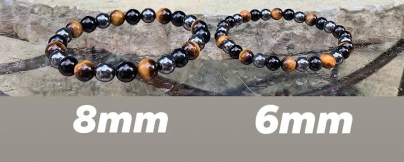 May include: Two beaded bracelets featuring alternating round tiger eye, black obsidian, and metallic hematite beads. The left bracelet is labeled 8mm and the right bracelet is labeled 6mm, indicating the specific diameter of the beads used in each piece.