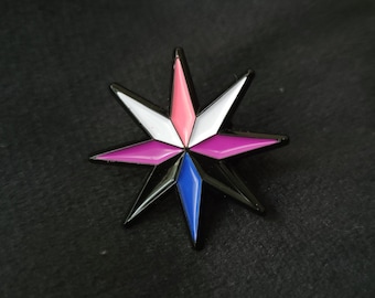 May include: A black metal pin shaped like a six-pointed star with pink, white, blue, and purple enamel.
