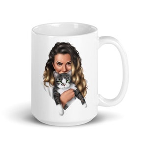May include: White ceramic mug with a colorful illustration of a woman with long blonde hair holding a gray and white cat.