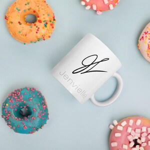 May include: White ceramic mug with a black cursive letter "J" and the word "Jenvielle" written below it.