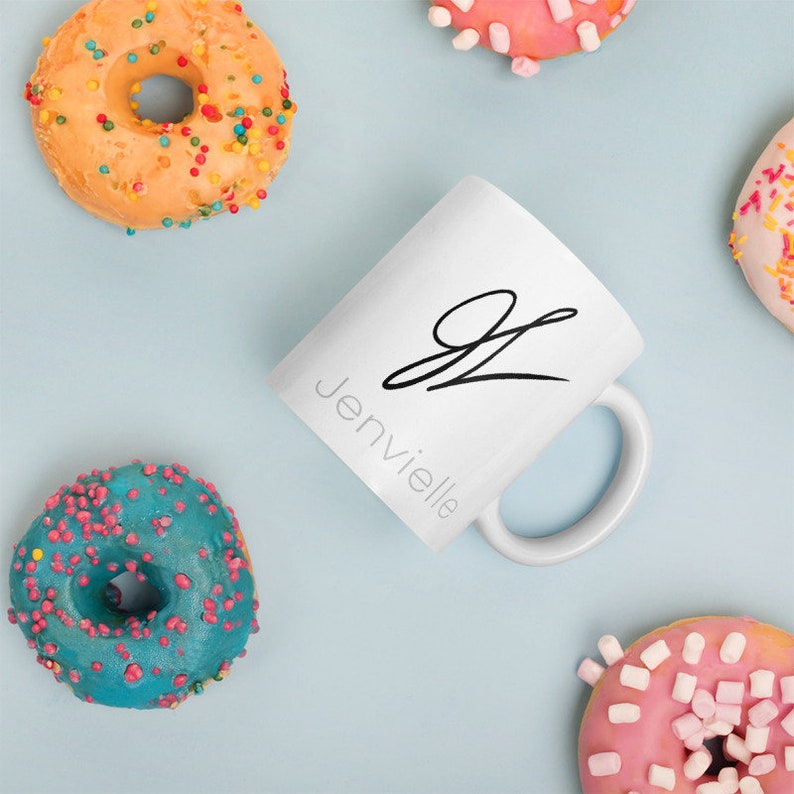 May include: White ceramic mug with a black cursive letter "J" and the word "Jenvielle" written below it.