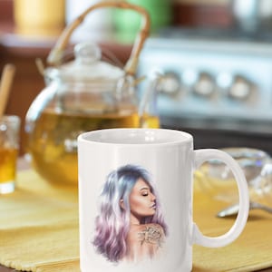 May include: White ceramic mug with a colorful illustration of a woman with purple and blue hair and a rose tattoo on her shoulder.