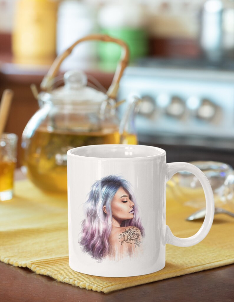 May include: White ceramic mug with a colorful illustration of a woman with purple and blue hair and a rose tattoo on her shoulder.