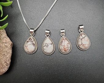May include: Four silver teardrop pendants with white and brown marbled stones. The pendants are on a silver chain.