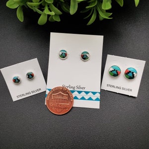 May include: Three pairs of sterling silver earrings with turquoise and red inlay designs. The earrings are displayed on white cards with the words "Sterling Silver" printed on them. A US penny is included for size reference.