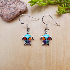 May include: Sterling silver earrings featuring a turquoise, orange, red, green, and purple inlaid turtle design.