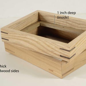 May include: Two unfinished wooden boxes, one stacked on the other. The top box is 1.5 inches (3.8 cm) outside and 1 inch (2.5 cm) deep inside. The sides are solid hardwood and 1/2 inch (1.3 cm) thick. The boxes have visible joinery.