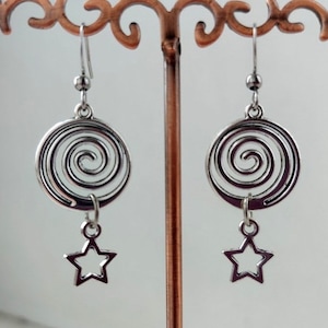 May include: Silver dangle earrings with a spiral design and a star charm.