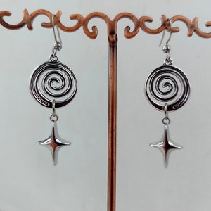 May include: Silver dangle earrings with a spiral design and a star charm.