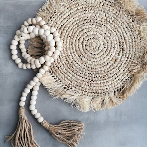 Offene Girlande aus rohen Holzperlen mit zwei Bast-Pompons 160 cm