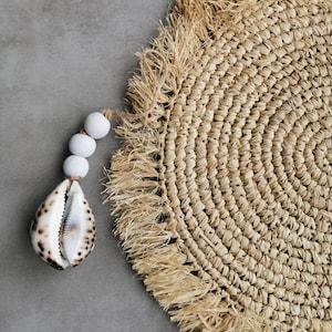 Necklace or door clasp made of white wooden beads with a large tiger shell