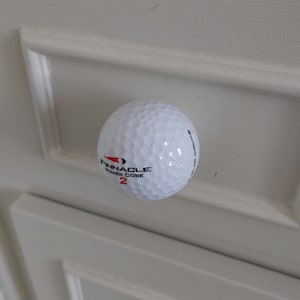 Peut inclure: Une balle de golf blanche avec du texte noir qui dit "Pinnacle Power Core 2" et du texte rouge qui dit "Straight Out".