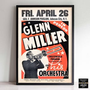 Puede incluir: Póster vintage enmarcado para un concierto de Glenn Miller, con un músico tocando el trombón. El póster tiene un marco negro y un diseño retro con texto naranja, negro y blanco. El texto incluye "FRI. APRIL 26" y "GLENN MILLER."