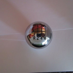Può includere: Un pomello del cambio in cromo con numeri neri 1, 3, 5, R, 2, 4 e 6.