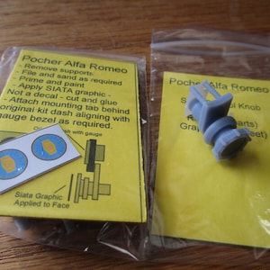 May include: A close-up of a blue plastic model car part, a gear shift knob, with instructions for assembly. The instructions include the text "Pocher Alfa Romeo" and "Siata Graphic Applied to Face".