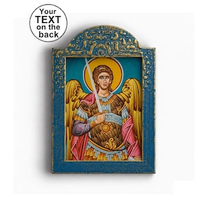 Op de afbeelding: Een rechthoekig houten icoon met een geschilderde figuur van een engel met gouden vleugels, een gele halo en een zwaard, geplaatst in een getextureerd blauw frame met gouden accenten. Een cirkelvormige afbeelding linksboven bevat de tekst Your TEXT on the back.